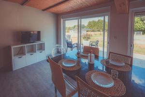 a dining room with a table with chairs and a television at Domaine Serenity in Payzac