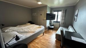 a bedroom with a bed and a television in it at Kroderen Kro & motel AS in Hamremoen