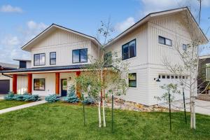 a white house with trees in the yard at Sunlight cottage in Steamboat Springs