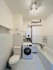 a bathroom with a toilet and a washing machine at Apartmá Luxura in Děčín +73 photos