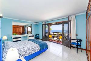 - une chambre bleue avec un lit et un balcon dans l'établissement Villa Speranza by Villa Plus, à Puerto del Carmen