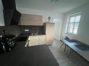a kitchen with wooden cabinets and a table in it at Schöne Ferienwohnung im Herzen von Prüm in Prüm