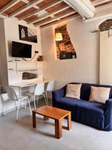 a living room with a blue couch and a table at Appartamento BIANCA in Montignoso
