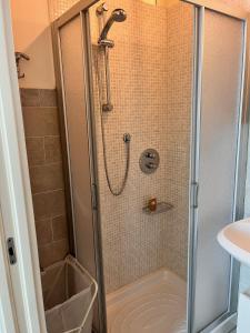 a shower with a glass door in a bathroom at Appartamento BIANCA in Montignoso +12 photos