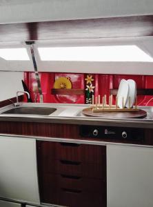 a kitchen with a sink and a plate with utensils at 70's Tiny Boat in Lisbon +17 photos