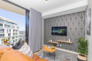 un salon avec un canapé et une télévision sur un mur dans l'établissement Exclusive Apartment, Ellipse, à Midrand