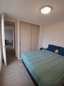 Un dormitorio con una cama azul y un pasillo en Apartamento a pasos del Mar, en La Serena 9 fotos más