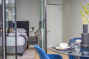 une chambre avec un lit, une table et des chaises dans l'établissement Exclusive Apartment, Ellipse, à Midrand 43 autres photos