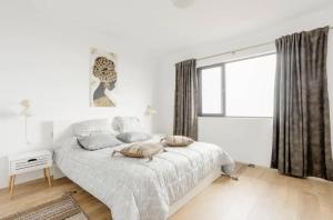 Un dormitorio blanco con una cama y una ventana. en Serenity Haven, en Icod de los Vinos