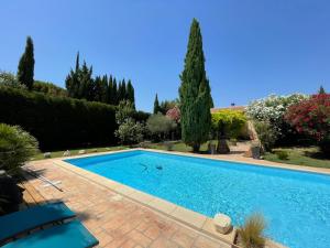 a swimming pool in a yard with trees and bushes at Studio Le Pitchoun in Pernes-les-Fontaines