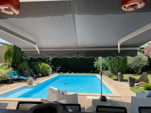 a swimming pool with an umbrella and some chairs at Studio Le Pitchoun in Pernes-les-Fontaines