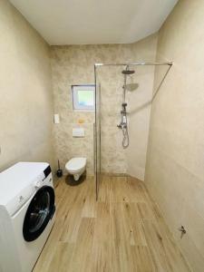 a bathroom with a shower and a washing machine at Apartment Maribel in Tribanj-Krušćica
