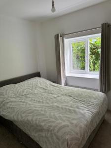 a bed in a bedroom with a window at Modern 2 bedroom Apartment in Frodsham