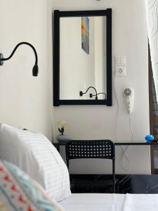 a bedroom with a mirror and a chair and a bed at Hotel Liliana in Agia Marina Aegina +20 photos