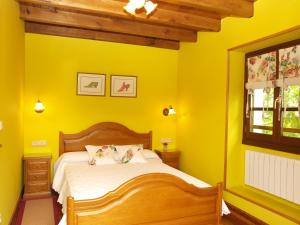 a yellow bedroom with a bed and a window at Hostal Rural Onbordi in Lesaka