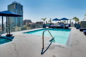 a swimming pool with chairs and umbrellas on a building at Downtown Los Angeles Condo with Rooftop Pool Access in Los Angeles
