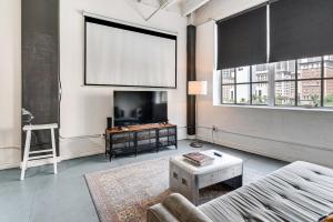 a living room with a couch and a tv at Downtown Los Angeles Condo with Rooftop Pool Access in Los Angeles