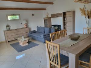 een woonkamer met een tafel en een blauwe bank bij Maison jumelée clôturée in Linguizzetta