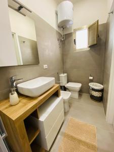 ein Badezimmer mit Waschbecken und Toilette in der Unterkunft Il Cortiletto Casa Vacanze in Pachino