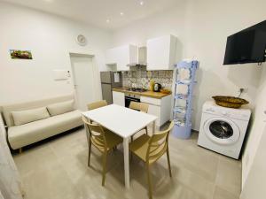 eine Küche und ein Wohnzimmer mit einem Tisch und einer Waschmaschine in der Unterkunft Il Cortiletto Casa Vacanze in Pachino + 4 Fotos