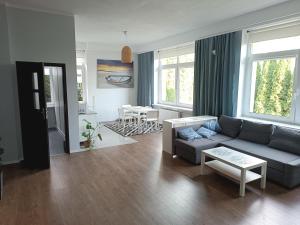 a living room with a blue couch and a table at VillaMaria in Gdańsk