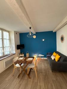 ein Wohnzimmer mit einem Tisch und einer blauen Wand in der Unterkunft Bulles de bonheur - Carcassonne in Carcassonne