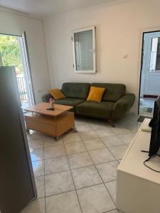 - un salon avec un canapé vert et une table basse dans l'établissement TIA Sveti Stefan, à Budva