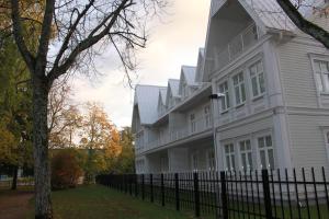 una casa blanca con una valla delante en Villa Lehe Ranna Apartment, en Pärnu