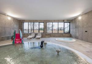 a room with a pool with a penguin in the water at STAR Apartament & Spa Dziwnów in Dziwnów