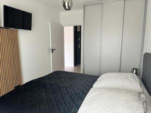 a bedroom with a bed and a flat screen tv at STAR Apartament & Spa Dziwnów in Dziwnów +20 photos