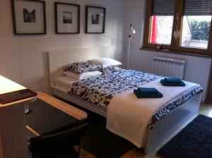 a bedroom with two beds and a table and a window at Apartment Block A in Belgrade