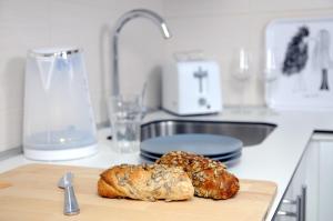 two loaves of bread on a cutting board on a kitchen counter at Apartment Block A in Belgrade