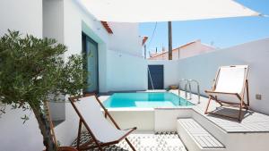 a patio with a pool and two chairs and a house at Casas da Amieira - Casa Terracota in Amieira