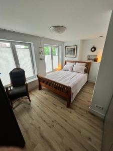 a bedroom with a large bed and a chair at Appartement Plein 1944 in Nijmegen