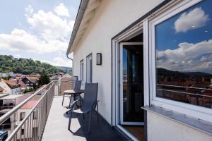 a balcony with a table and chairs and a window at Sander's Apartments Landstuhl in Landstuhl