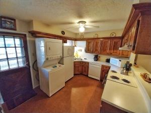 una cucina con elettrodomestici bianchi e armadietti in legno di Valley Condo 124 - Creekside - WiFi - Hot Tub - Fireplace - Washer - Dryer - Playground a Red River
