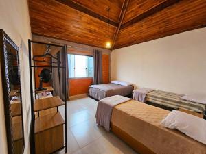 ein Schlafzimmer mit zwei Betten in einem Zimmer in der Unterkunft Amantes da Serra Ibitipoca, venha e surpreenda-se! in Conceição da Ibitipoca