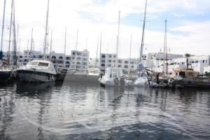 a group of boats docked in a harbor with buildings at Marina Cap Monastir- Appart'Hôtel in Monastir