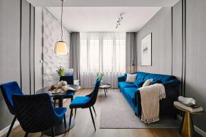 salon z niebieską kanapą i stołem w obiekcie Wielopole17 Max Apartment with AC w Krakowie