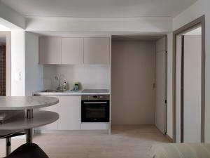 a kitchen with white cabinets and a table at Apt al mare in Epanomi