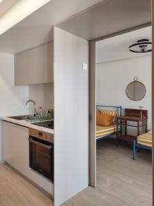 a kitchen with an open door to a living room at Apt al mare in Epanomi +25 photos