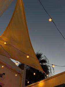 a large yellow umbrella with lights on a building at Blu Marlin in SantʼAntìoco