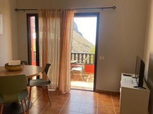 a living room with a table and a sliding glass door at Casa Roja La Calera in Valle Gran Rey