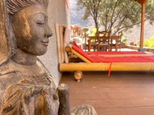 a statue of a woman sitting next to a bed at Casa Roja La Calera in Valle Gran Rey