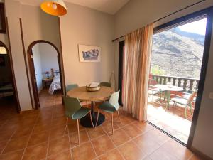 a dining room with a table and chairs and a balcony at Casa Roja La Calera in Valle Gran Rey