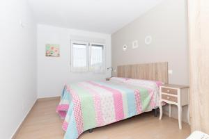 Un dormitorio blanco con una cama y una mesita de noche. en London - LA COLINA, en San Miguel de Meruelo 18 fotos más