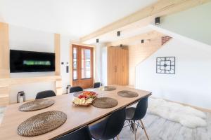 a dining room with a wooden table and chairs at Leśna Przystań Gorce in Nowy Targ