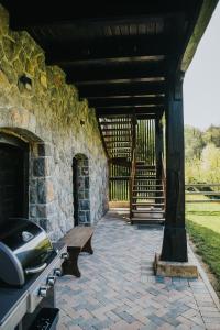 a stone building with a bench on a patio at Riverside House Krka in Zagradec
