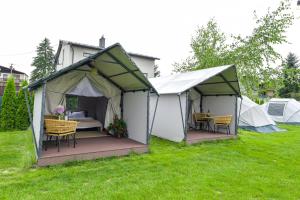 a tent with tables and chairs in a yard at KempingZator Glamping in Zator