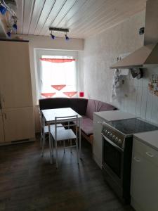 a kitchen with a table and a couch in a kitchen at 2 schnuckelige Wohnungen in Oberfranken in Helmbrechts +14 photos